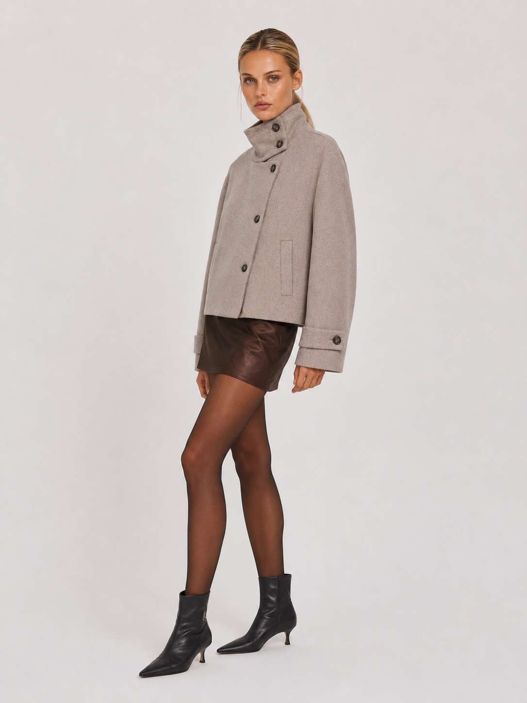 Graue Kurzjacke von der Seite, Ganzkörperaufnahme mit schwarzen Stiefeletten