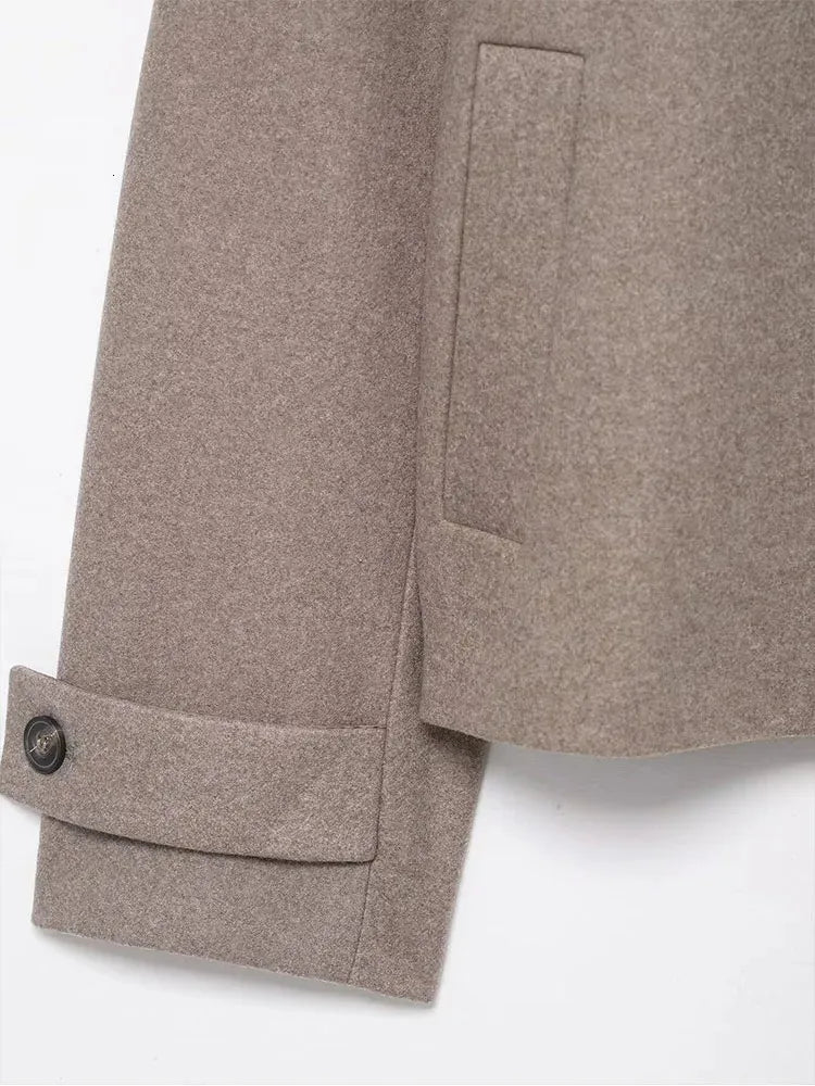 Detailaufnahme des Ärmelabschlusses mit Knopfriegel an der grauen Kurzjacke
