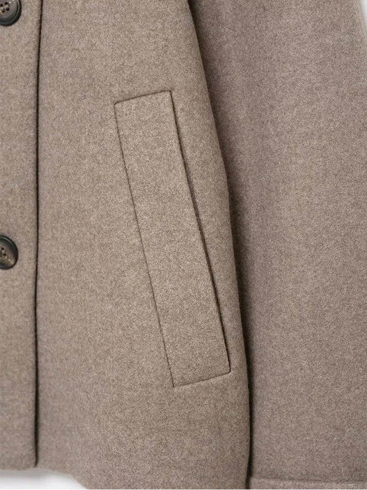 Detail der aufgesetzten Tasche und der Knöpfe an der Front der grauen Kurzjacke